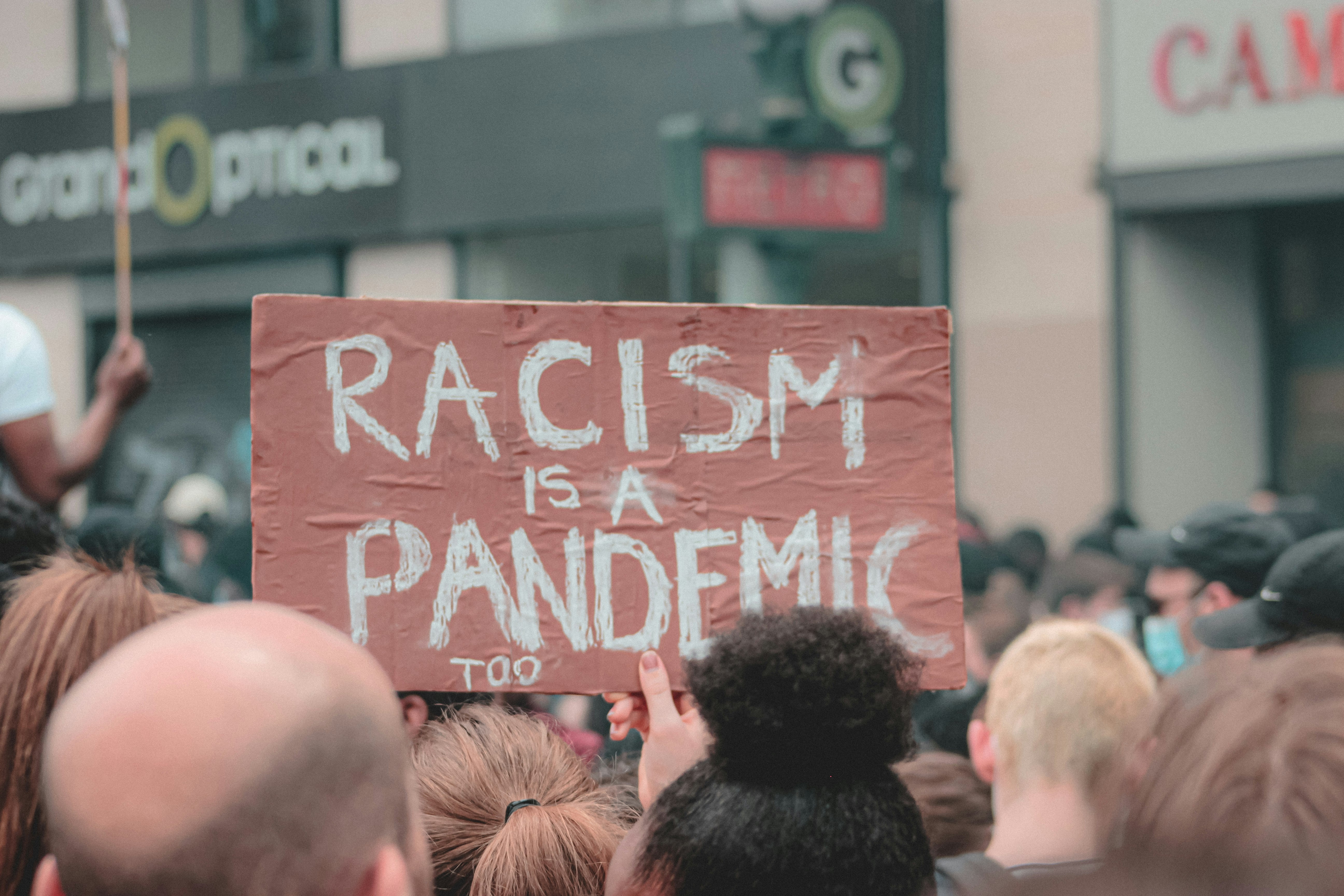 people holding red and white happy birthday signage during daytime